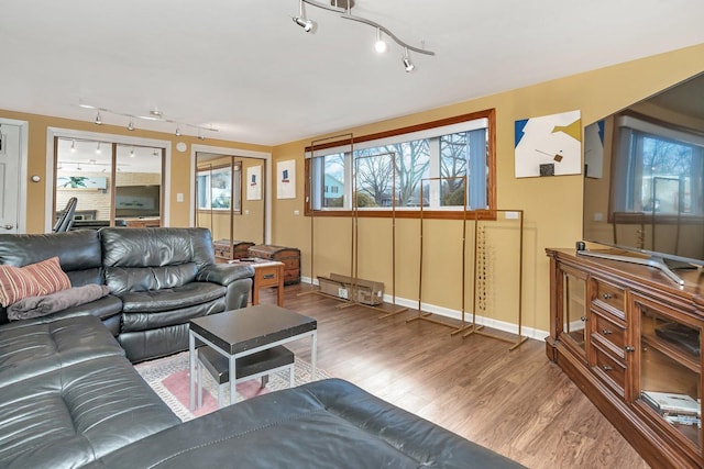 living area with baseboards and wood finished floors