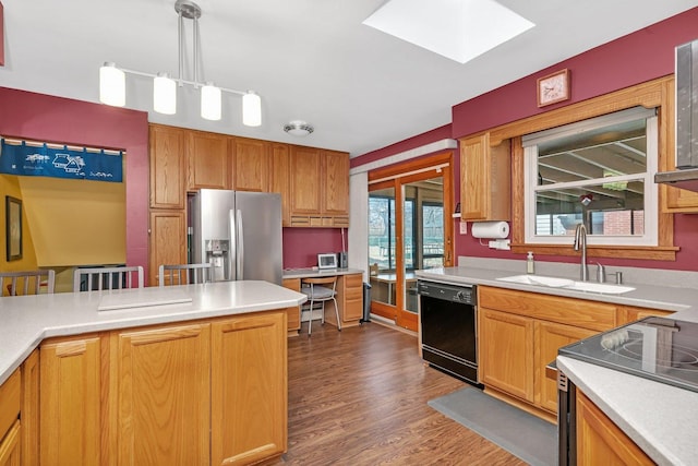 kitchen featuring black dishwasher, light countertops, electric range oven, a sink, and stainless steel fridge