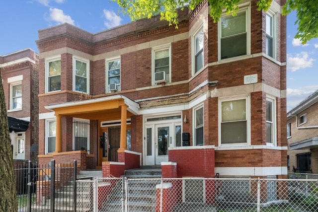 view of property with a fenced front yard, cooling unit, a gate, and brick siding