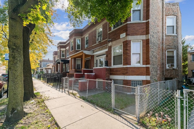 view of home's exterior with a fenced front yard, a residential view, and brick siding