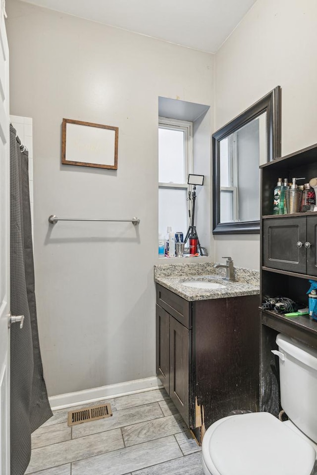 5412 S Wood St, Chicago, IL 60609 - bathroom featuring toilet, vanity, baseboards, wood tiled floor, and visible vents