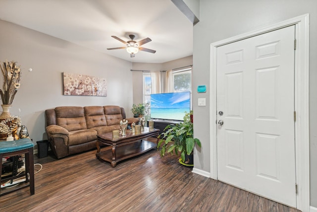 living room with ceiling fan, dark wood-style flooring, and baseboards