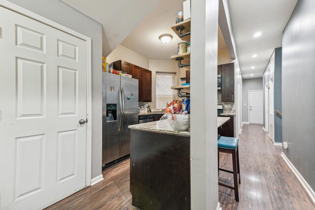 5412 S Wood St, Chicago, IL 60609 - kitchen with a kitchen bar, stainless steel refrigerator with ice dispenser, baseboards, dark wood finished floors, and light stone countertops