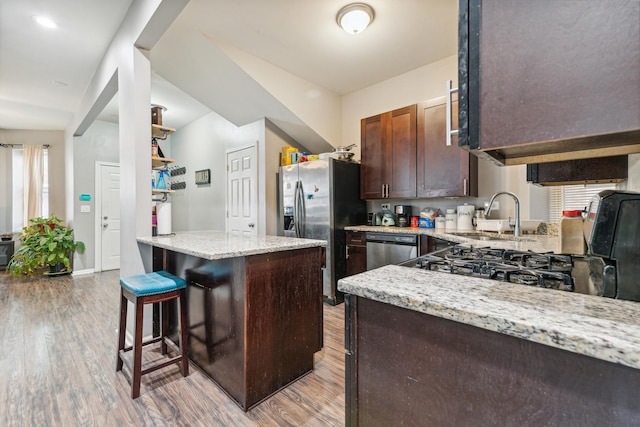 5412 S Wood St, Chicago, IL 60609 - kitchen with a breakfast bar area, a sink, stainless steel appliances, and light wood finished floors