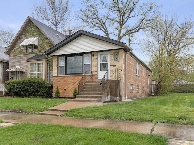 bungalow featuring a front yard and brick siding