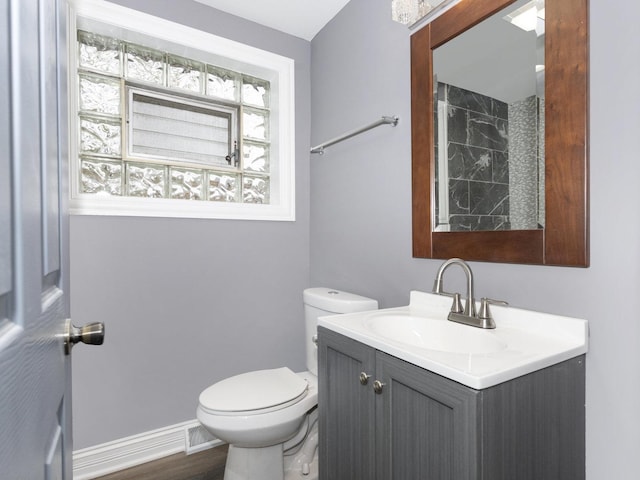 bathroom featuring visible vents, vanity, toilet, and baseboards