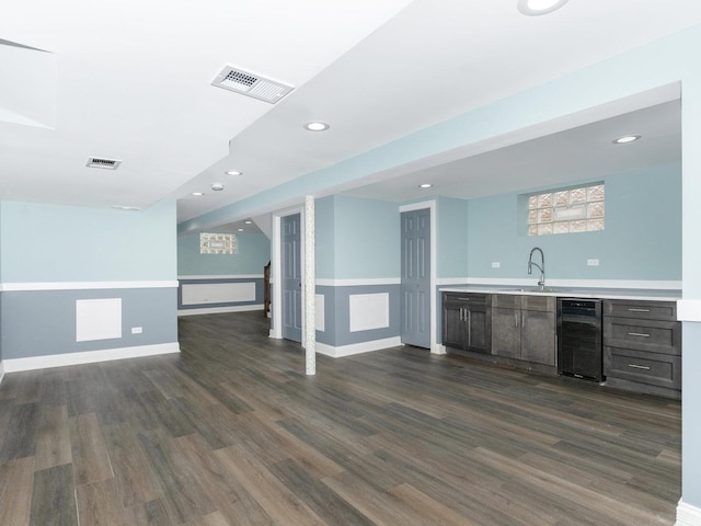 bar with beverage cooler, visible vents, and dark wood-style flooring