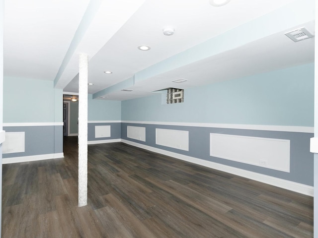 finished below grade area featuring dark wood-style floors, recessed lighting, visible vents, and baseboards