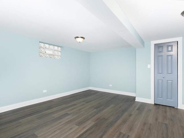 spare room with dark wood-type flooring and baseboards