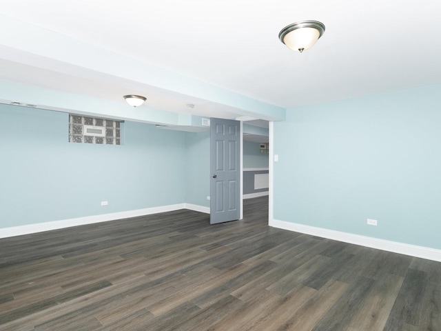 empty room with dark wood finished floors and baseboards