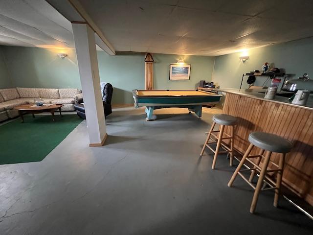 rec room with finished concrete flooring, billiards, and a dry bar