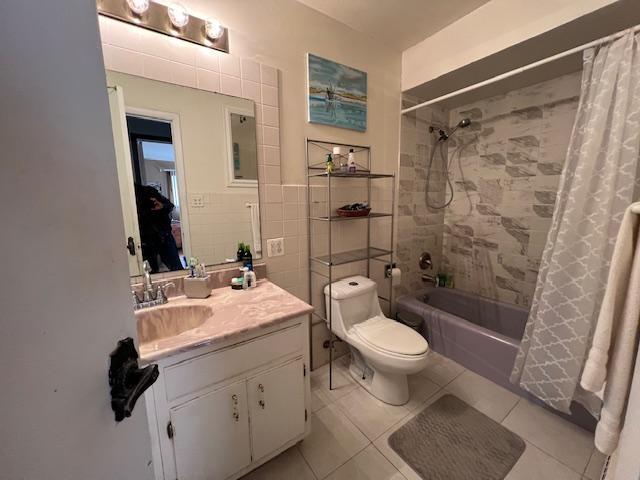 full bathroom featuring shower / tub combo with curtain, tile walls, toilet, vanity, and tile patterned floors