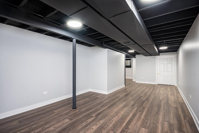 finished below grade area featuring wood finished floors, visible vents, and baseboards