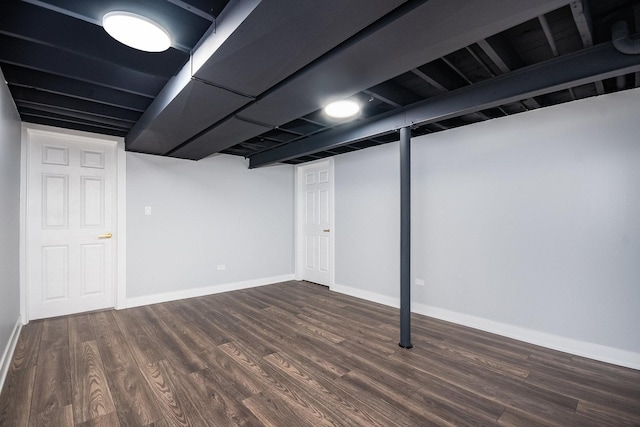 finished below grade area featuring dark wood-style floors and baseboards