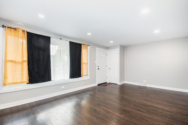 spare room with recessed lighting, dark wood finished floors, and baseboards