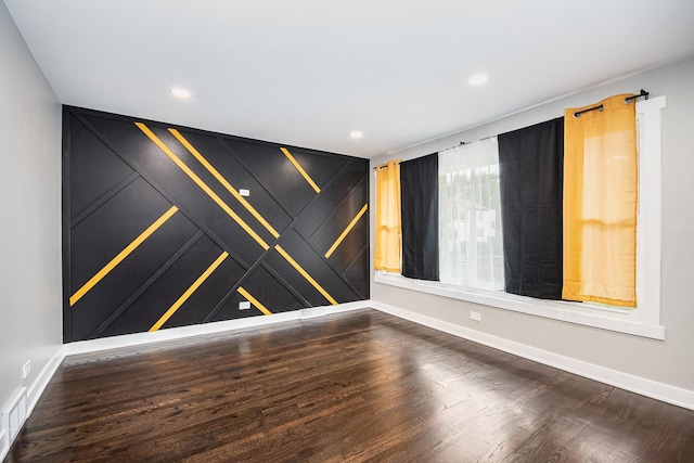 spare room with recessed lighting, baseboards, and wood finished floors