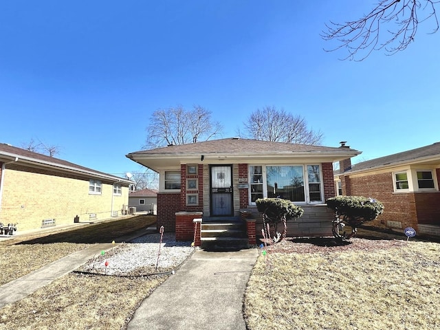 view of front of property with brick siding and roof with shingles