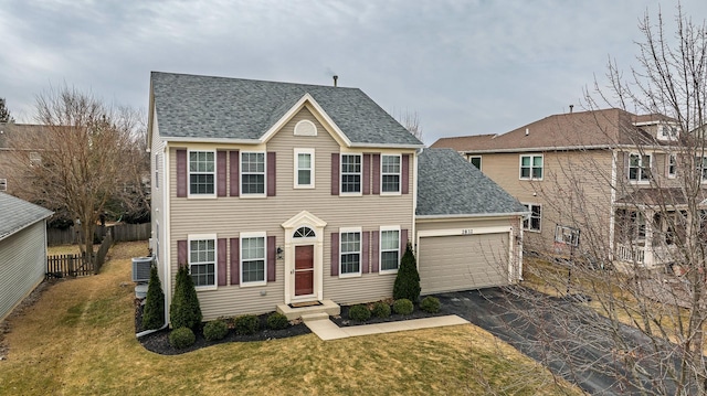 colonial-style house featuring cooling unit, a garage, fence, driveway, and a front lawn