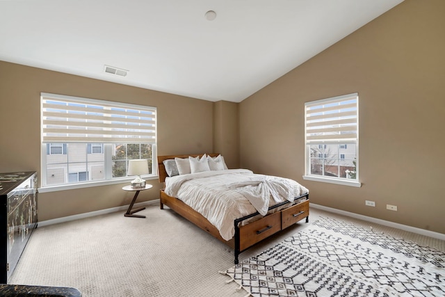 bedroom with light carpet, vaulted ceiling, visible vents, and baseboards