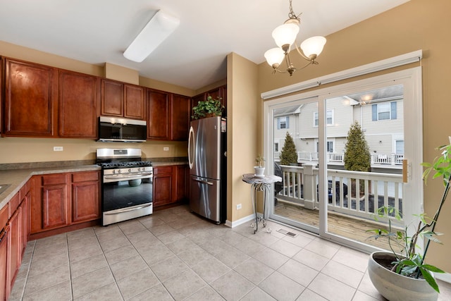 kitchen featuring pendant lighting, stainless steel appliances, visible vents, light tile patterned flooring, and a chandelier