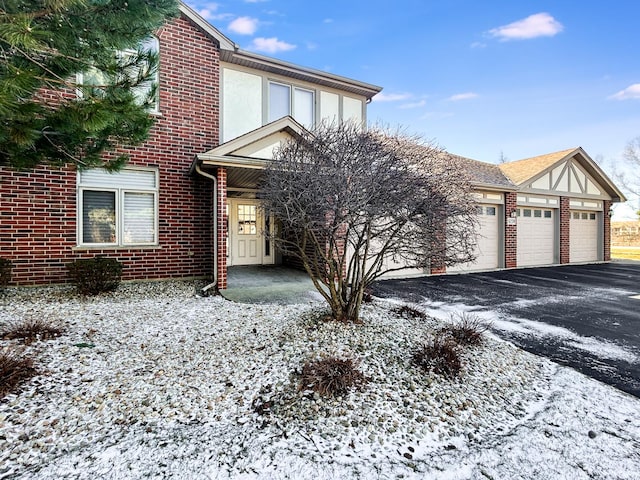 view of front of home featuring brick siding and aphalt driveway