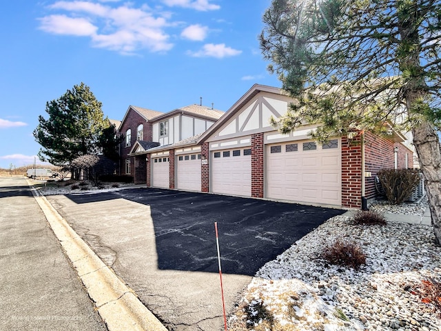 exterior space featuring aphalt driveway and brick siding