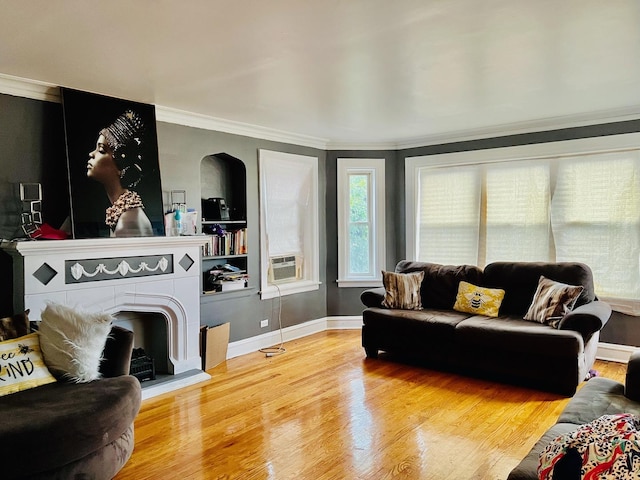 living area with cooling unit, a fireplace, wood finished floors, baseboards, and ornamental molding