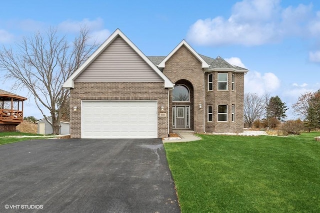 traditional home with aphalt driveway, brick siding, an attached garage, and a front lawn