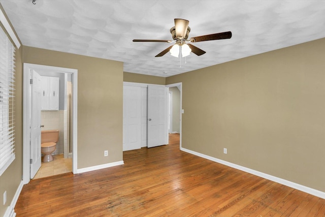 604 Park Lane Dr, Champaign, IL 61820 - unfurnished bedroom featuring hardwood / wood-style flooring, baseboards, connected bathroom, a closet, and a ceiling fan
