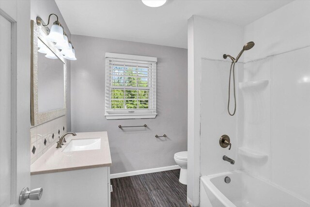 604 Park Lane Dr, Champaign, IL 61820 - full bathroom featuring toilet, vanity, wood finished floors, shower / bath combination, and baseboards