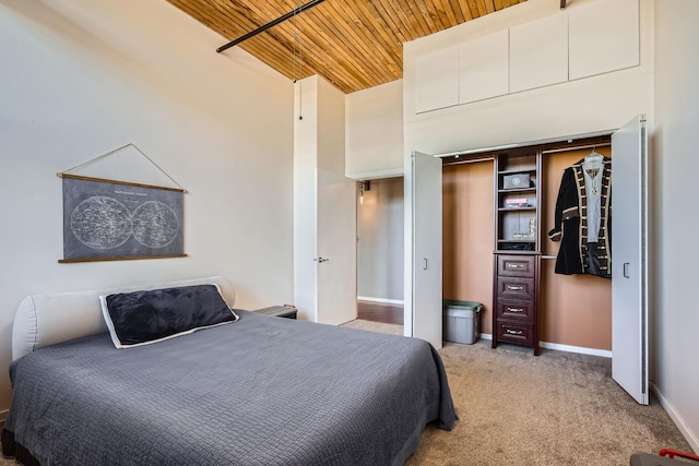 bedroom with a closet, light colored carpet, high vaulted ceiling, wooden ceiling, and baseboards