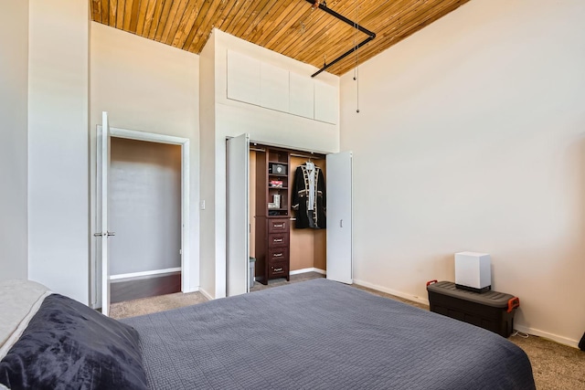 bedroom with high vaulted ceiling, carpet flooring, wood ceiling, and baseboards