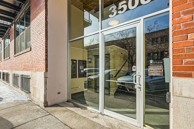 entrance to property featuring brick siding