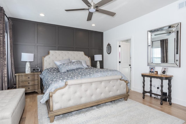 bedroom featuring recessed lighting, light wood-type flooring, visible vents, and a decorative wall