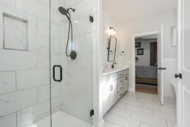 full bath with marble finish floor, a shower stall, connected bathroom, and vanity