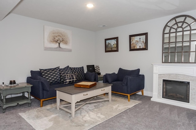 carpeted living room featuring visible vents and a glass covered fireplace