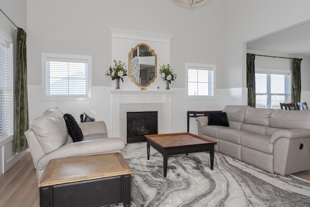 living room featuring a wainscoted wall, a fireplace, and light wood-style flooring