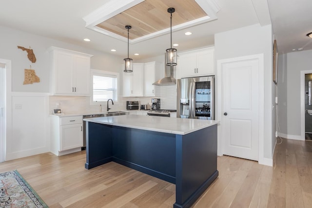 kitchen with tasteful backsplash, stainless steel fridge, light wood-style floors, and white cabinets