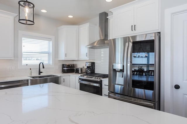 kitchen with appliances with stainless steel finishes, a sink, wall chimney exhaust hood, and tasteful backsplash