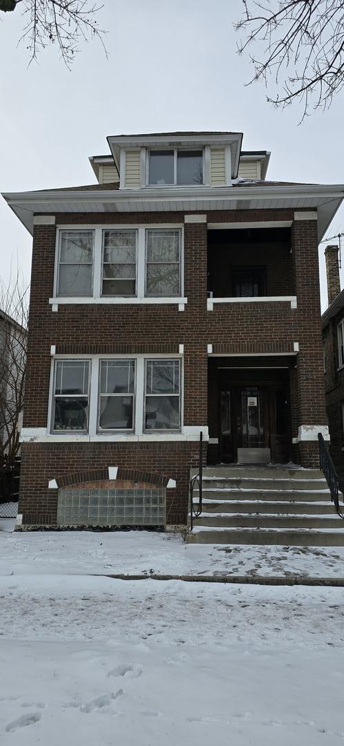 view of front of property with brick siding and a balcony