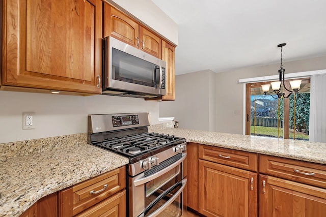 kitchen featuring stainless steel appliances, brown cabinets, decorative light fixtures, and light stone countertops