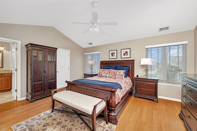 bedroom featuring baseboards, visible vents, vaulted ceiling, and light wood finished floors