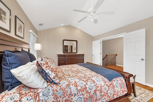 bedroom featuring lofted ceiling, ceiling fan, wood finished floors, visible vents, and baseboards