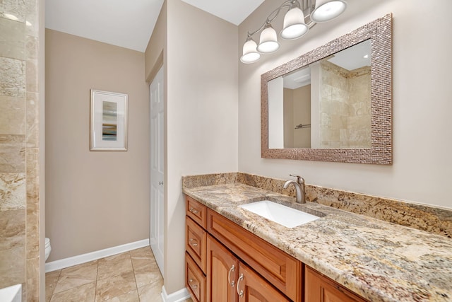 full bath featuring toilet, tiled shower, vanity, and baseboards