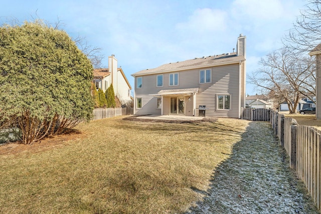 back of property featuring a fenced backyard, a patio, a chimney, and a lawn