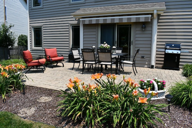 view of patio with fence and a grill