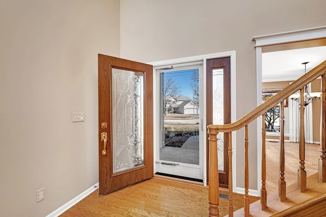 entrance foyer featuring stairs, light wood-type flooring, and baseboards