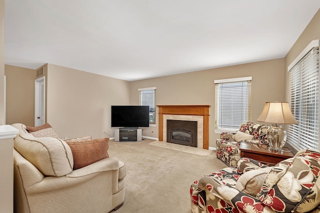 carpeted living room with a tile fireplace, visible vents, and baseboards