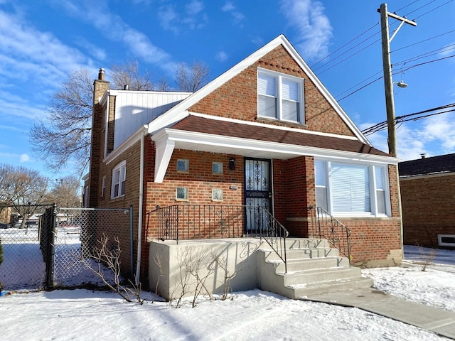 bungalow-style home with brick siding, a chimney, fence, and a gate