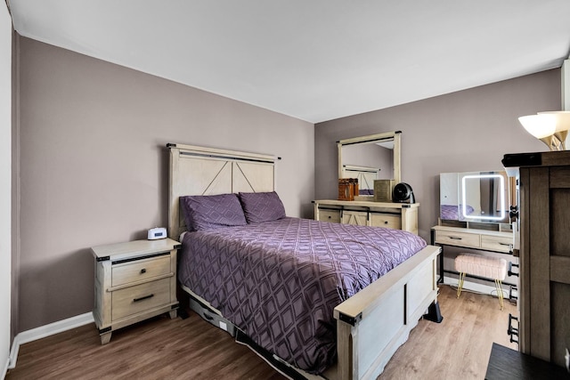 bedroom with baseboards and wood finished floors